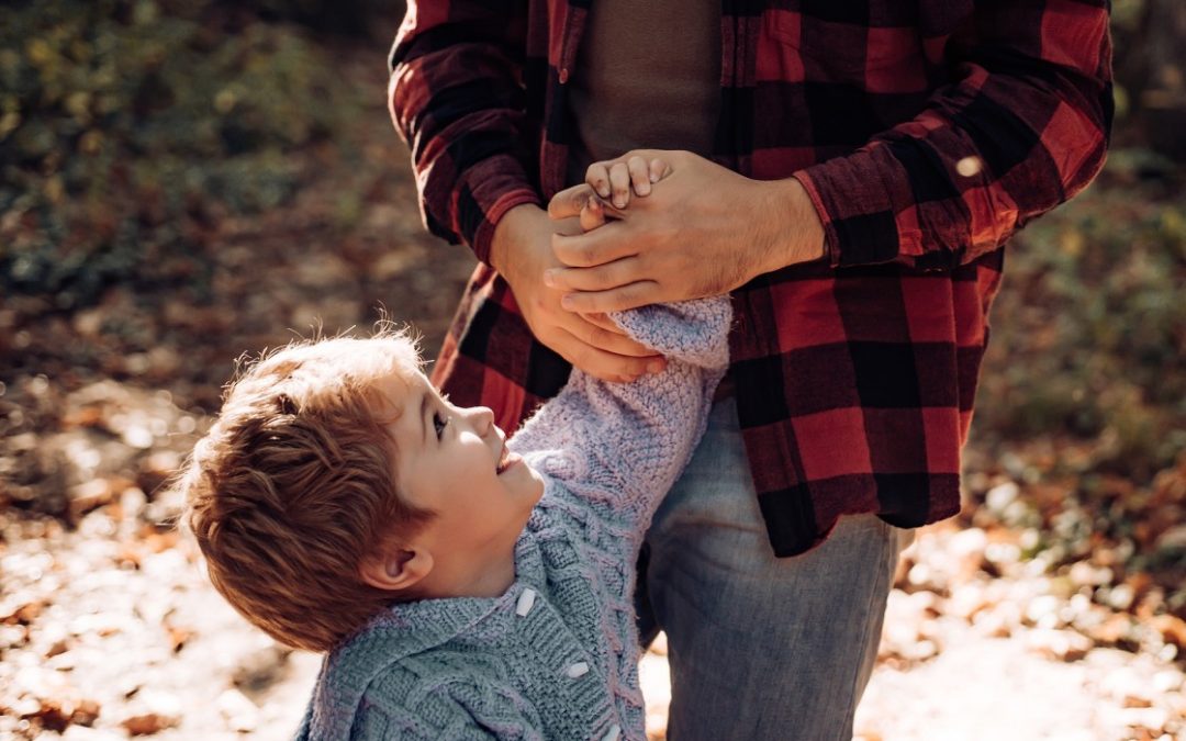 Father holding hands with son outside