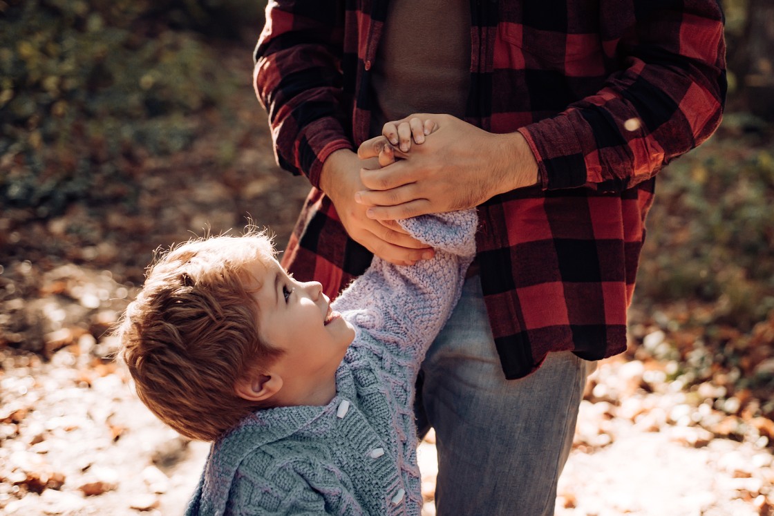 Father holding hands with son outside