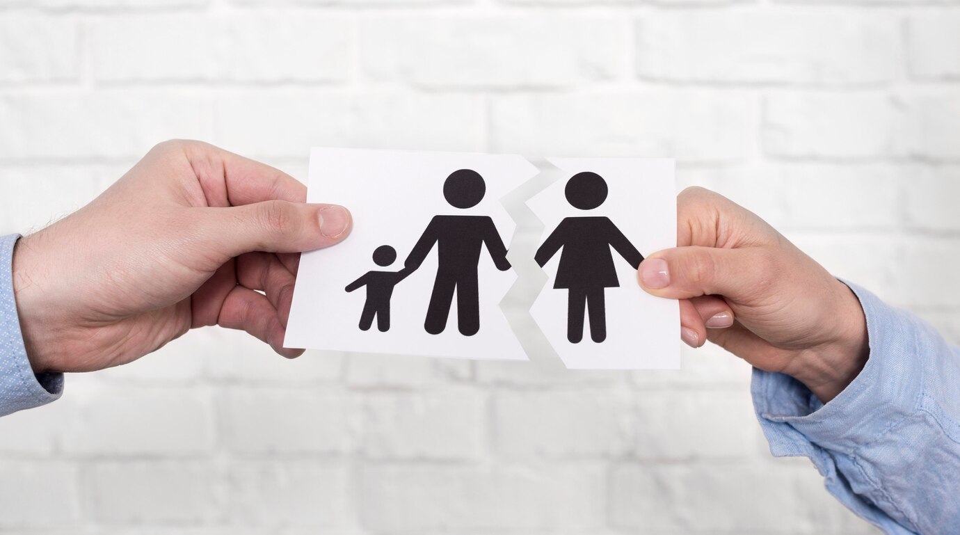 Hands tearing paper with graphic of family being split by divorce and family law issues